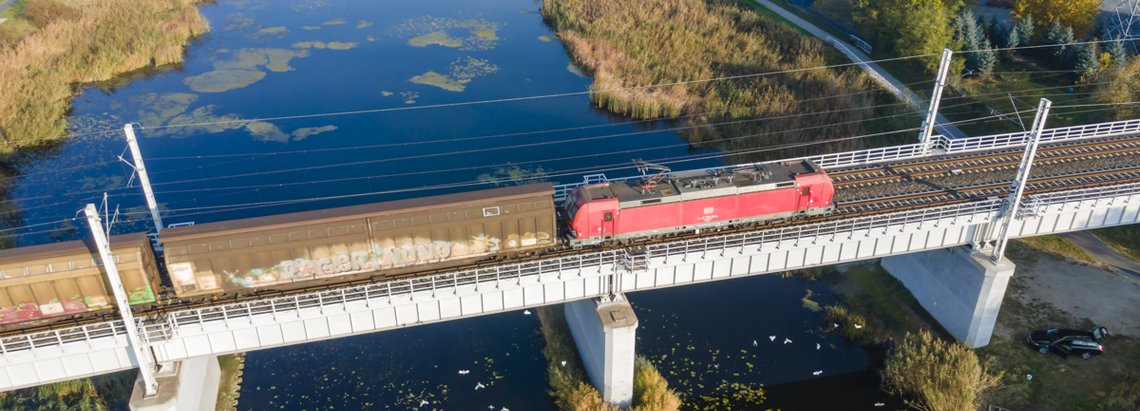 Train on the bridge crossing the river.  Temporary Capacity Restrictions